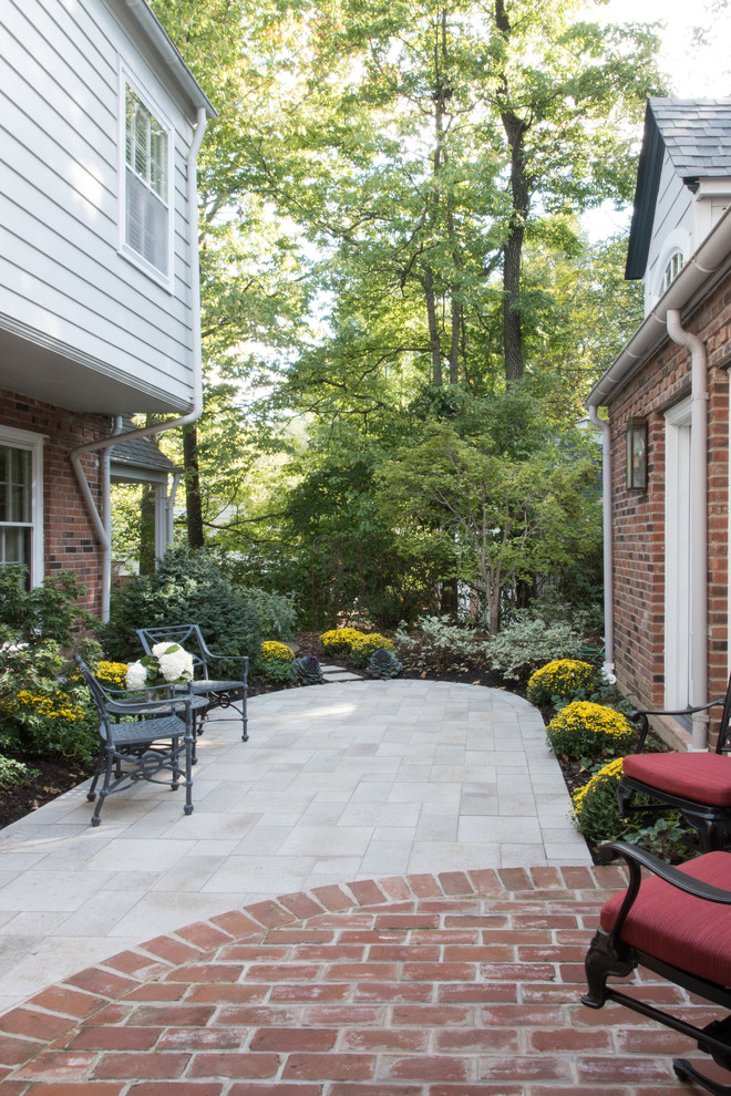Patio - mid-sized traditional courtyard stone patio idea in St Louis with no cover