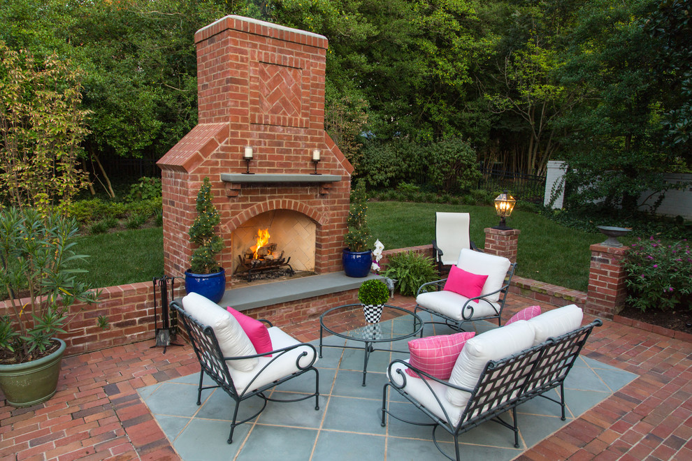 This is an example of a large classic back patio in St Louis with a fire feature, brick paving and no cover.