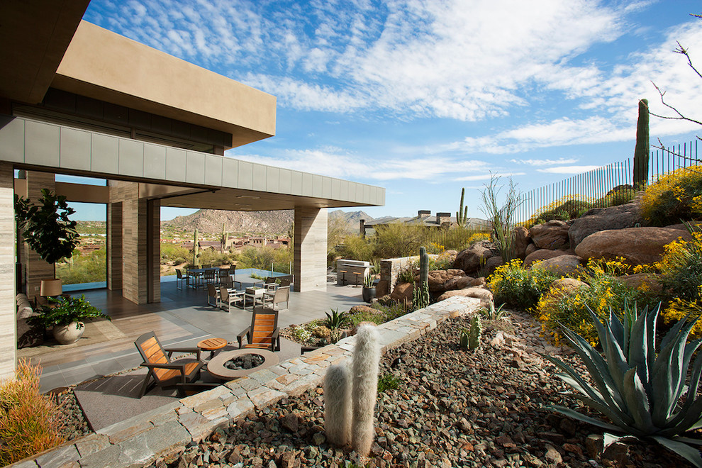 Photo of an expansive modern back patio in Phoenix with natural stone paving and no cover.