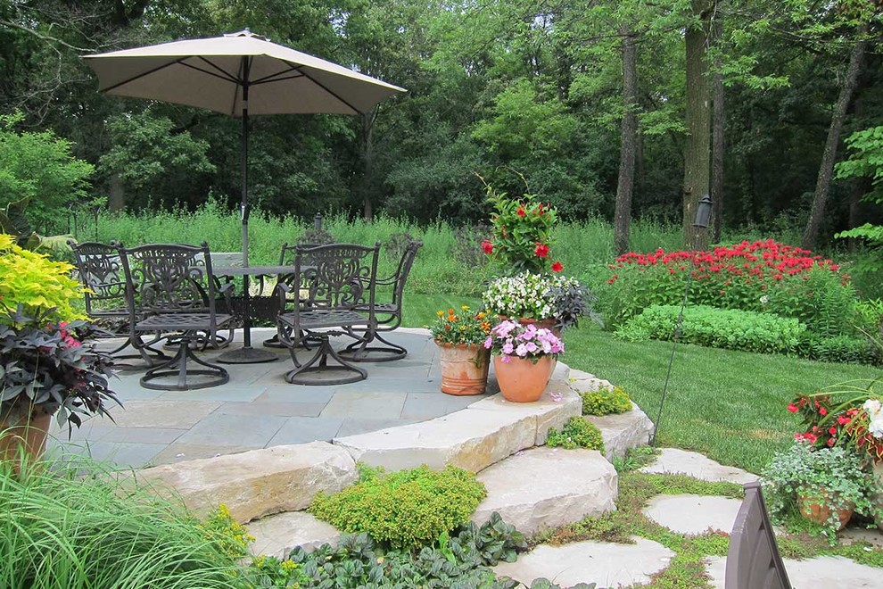 Imagen de patio tradicional grande sin cubierta en patio trasero con adoquines de piedra natural