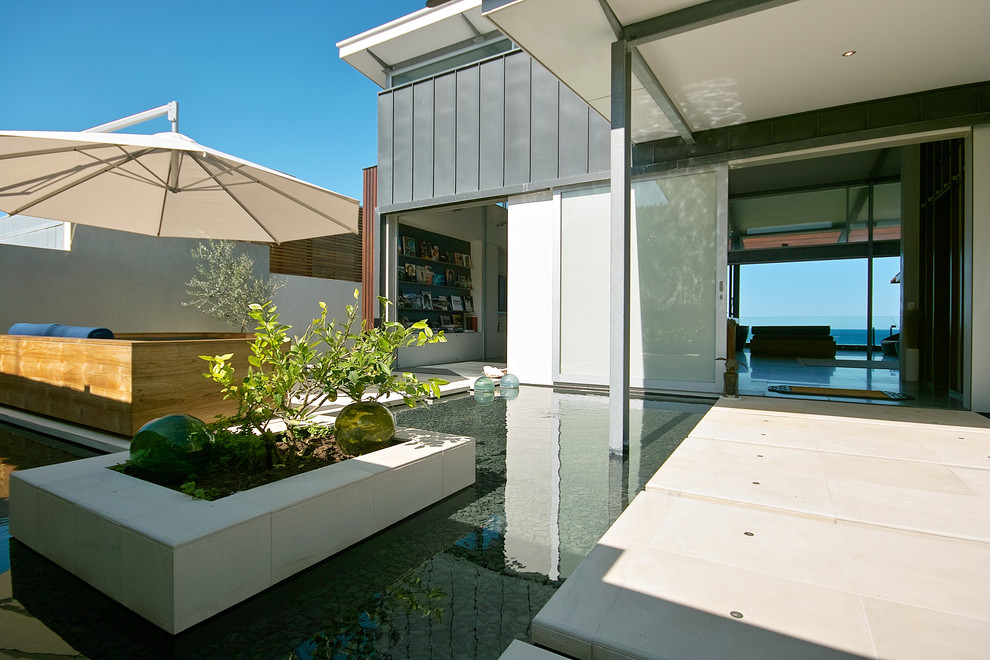 Стильный дизайн: двор среднего размера в морском стиле с фонтаном - последний тренд
