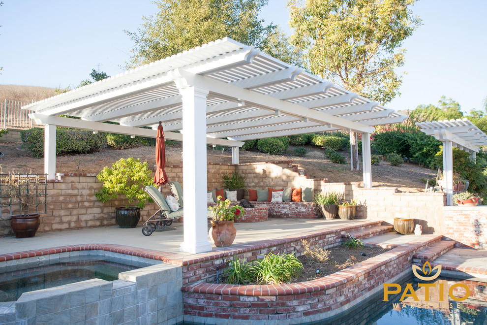 Photo of a classic back patio in Orange County with concrete slabs and a pergola.