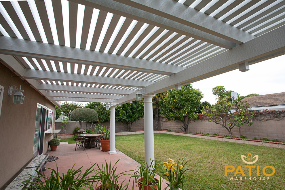 Example of a classic backyard concrete patio design in Orange County with a pergola