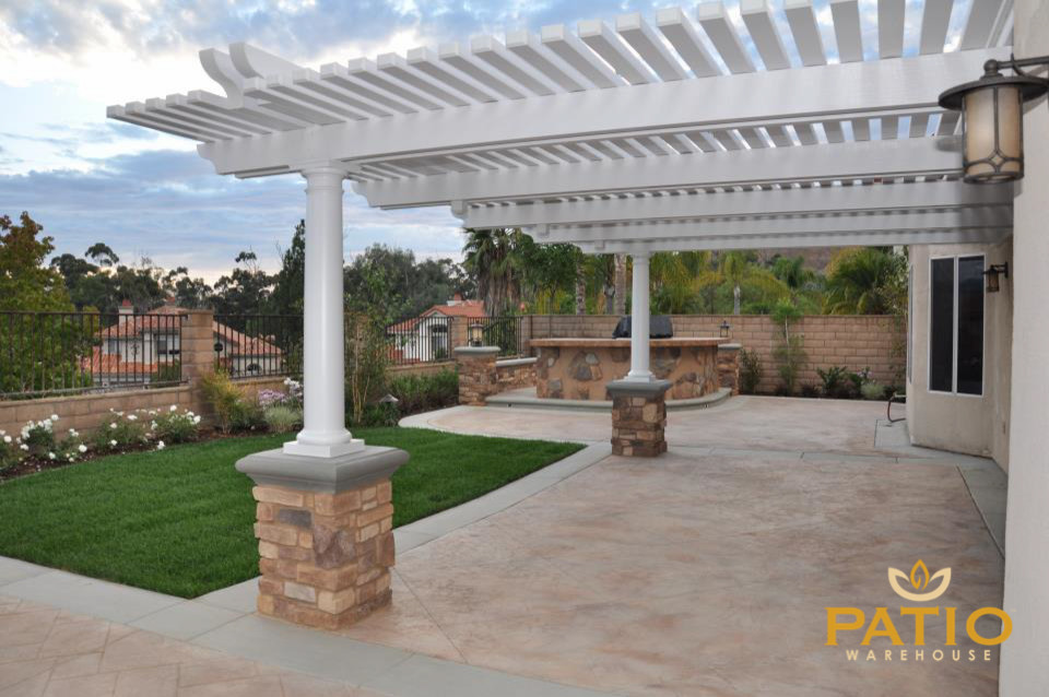 This is an example of a classic back patio in Orange County with stamped concrete and a pergola.