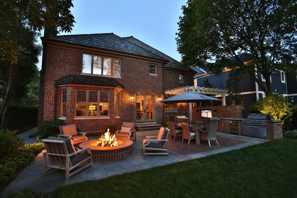 Inspiration for a mid-sized timeless backyard stone patio remodel in Chicago with a fire pit and a pergola