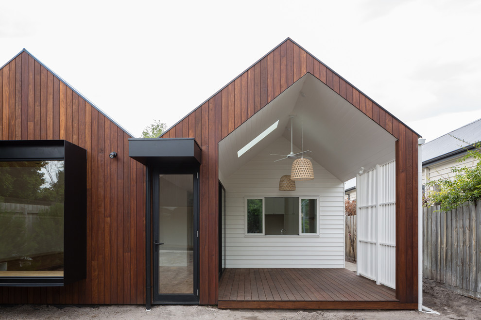 Aménagement d'une terrasse en bois arrière scandinave de taille moyenne avec une extension de toiture.