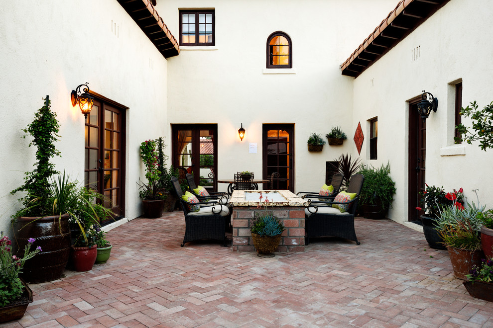 Esempio di un patio o portico mediterraneo con pavimentazioni in mattoni e nessuna copertura