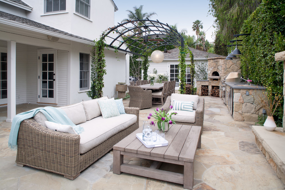 Aménagement d'une terrasse arrière classique avec une cuisine d'été, des pavés en pierre naturelle et une pergola.