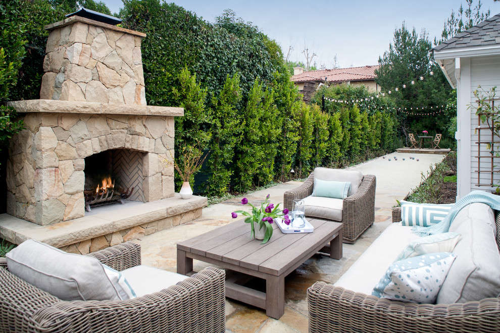Diseño de patio clásico sin cubierta en patio trasero con adoquines de piedra natural y chimenea