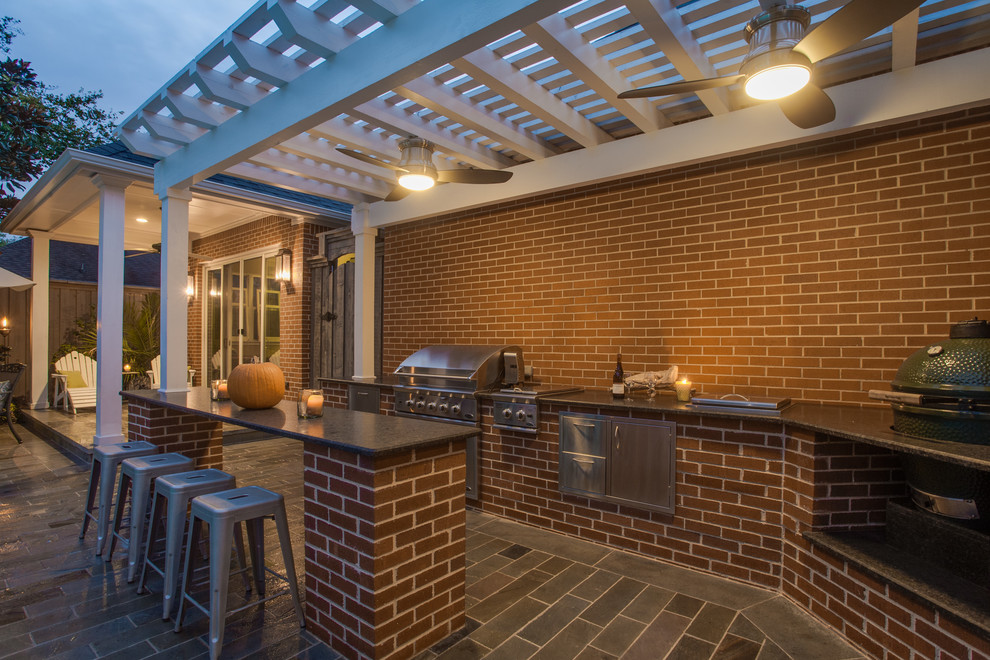 Klassische Pergola hinter dem Haus mit Outdoor-Küche und Natursteinplatten in Dallas