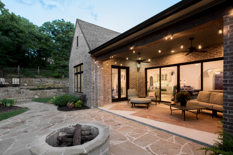Стильный дизайн: двор среднего размера на заднем дворе в классическом стиле с местом для костра, покрытием из каменной брусчатки и навесом - последний тренд