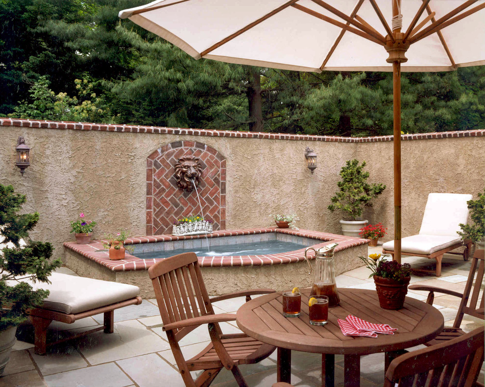 Exemple d'une terrasse arrière méditerranéenne avec un point d'eau, des pavés en pierre naturelle et aucune couverture.