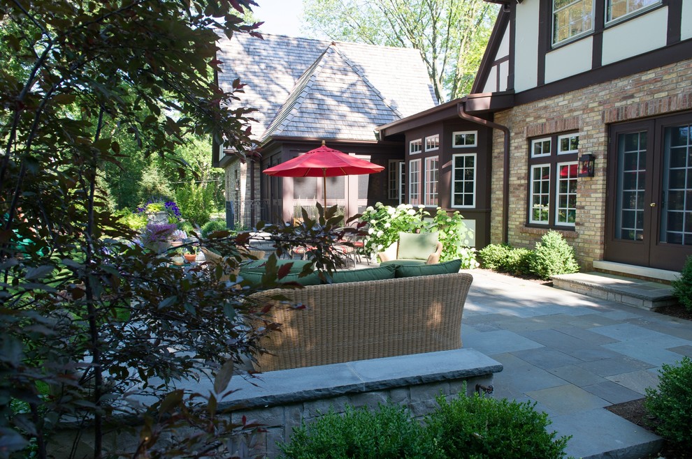 Immagine di un patio o portico classico dietro casa con pavimentazioni in pietra naturale