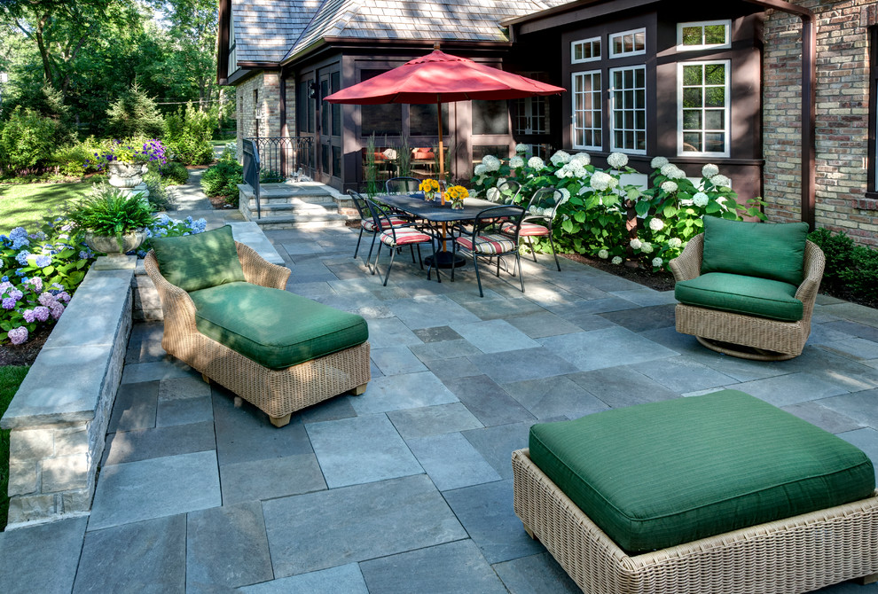 Example of a classic backyard stone patio design in Chicago