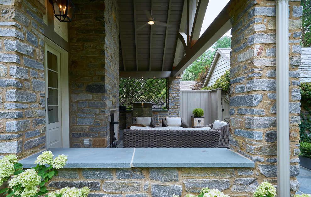 Large elegant backyard stone patio photo in Philadelphia with a fireplace and a roof extension
