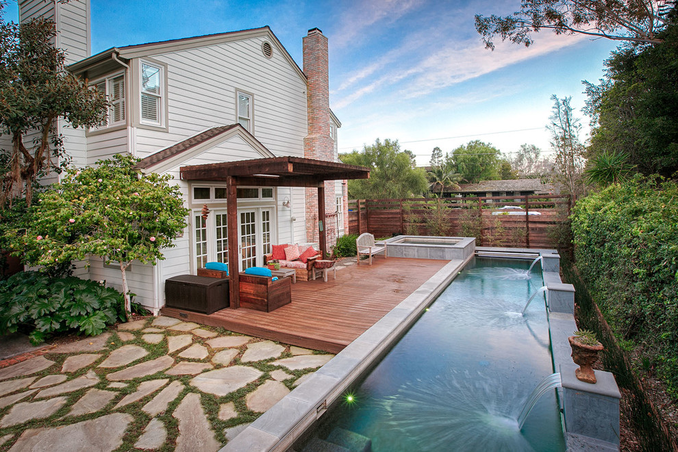 Large back patio in San Diego with a water feature and an awning.