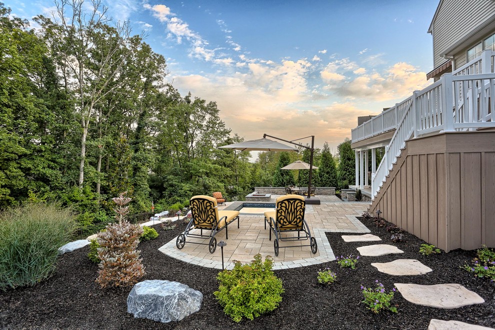 Immagine di un patio o portico country di medie dimensioni e dietro casa con un focolare e pavimentazioni in cemento