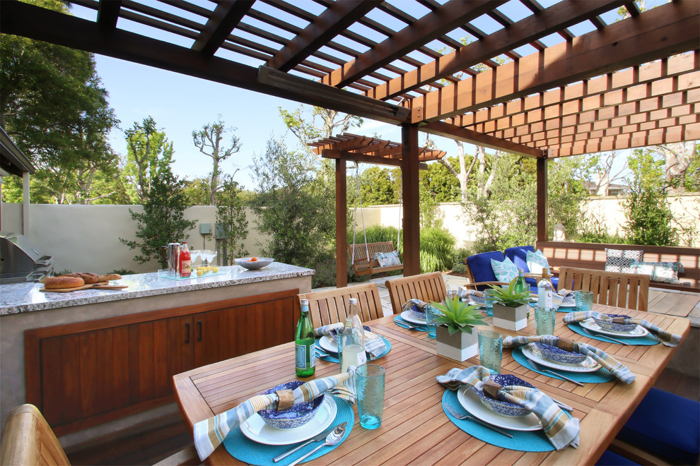 Patio kitchen - mid-sized transitional backyard stone patio kitchen idea in Los Angeles with a pergola