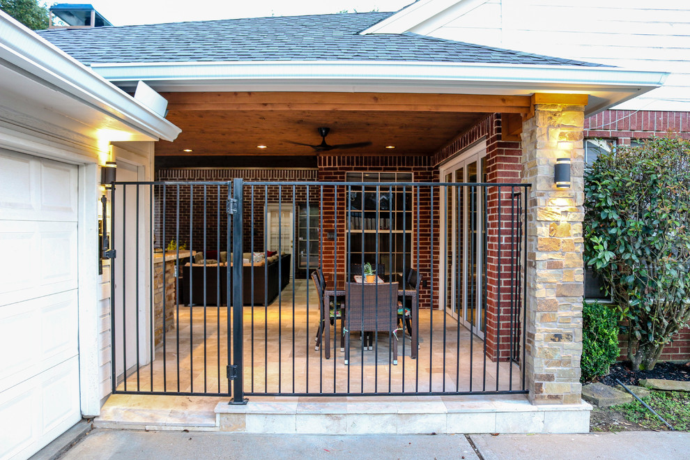 Klassischer Patio hinter dem Haus mit Natursteinplatten in Houston