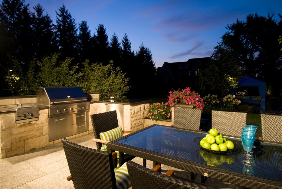 Photo of a contemporary back patio in Toronto with an outdoor kitchen, natural stone paving and no cover.