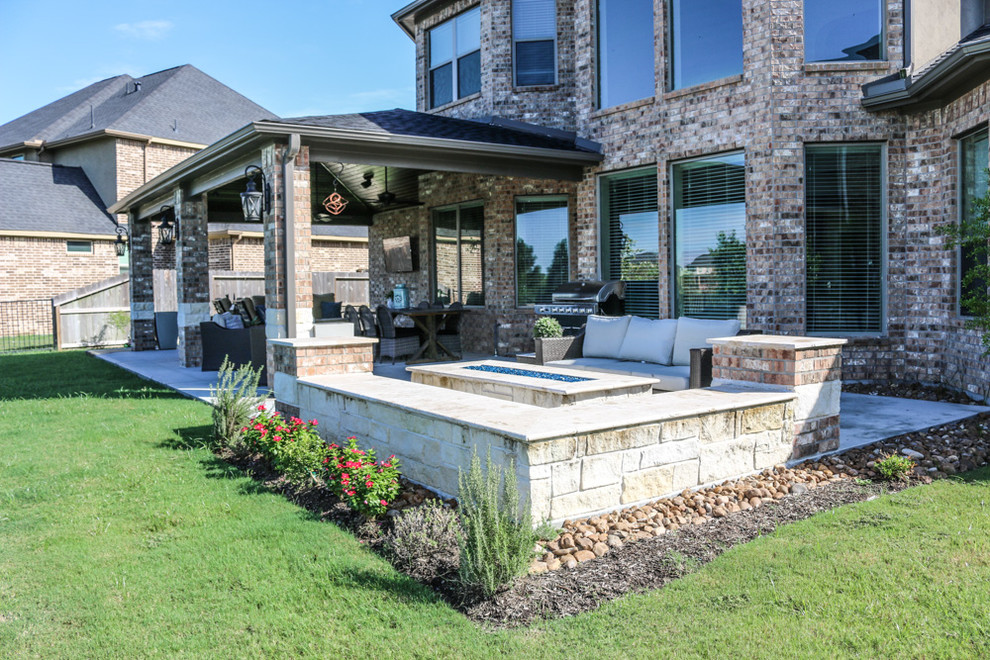 Стильный дизайн: большой двор на заднем дворе в классическом стиле с местом для костра, покрытием из бетонных плит и навесом - последний тренд