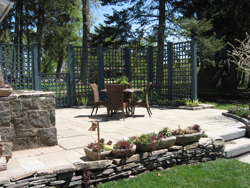 Inspiration for a small timeless backyard stone patio remodel in Newark