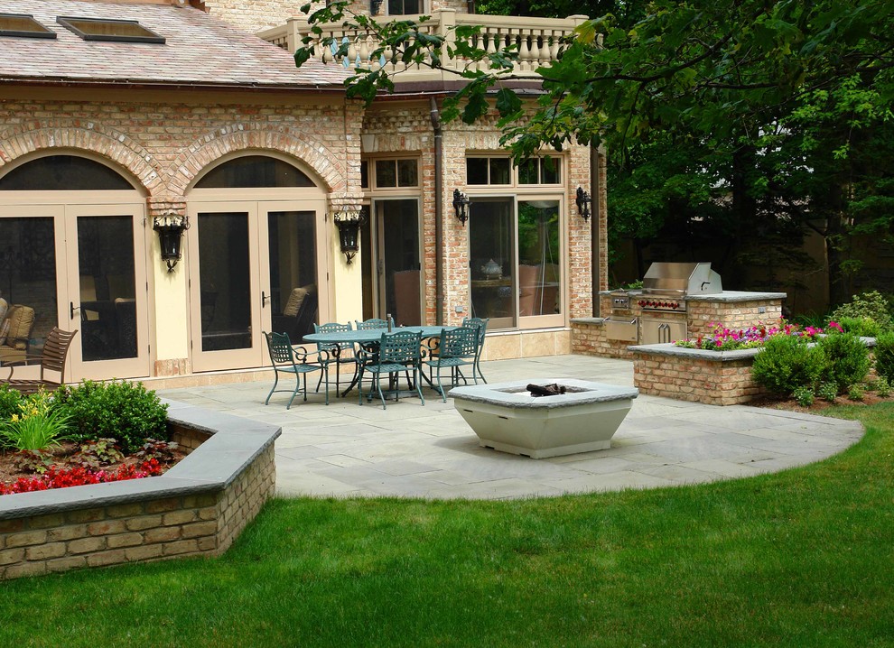 Esempio di un grande patio o portico chic dietro casa con un focolare, pavimentazioni in pietra naturale e nessuna copertura