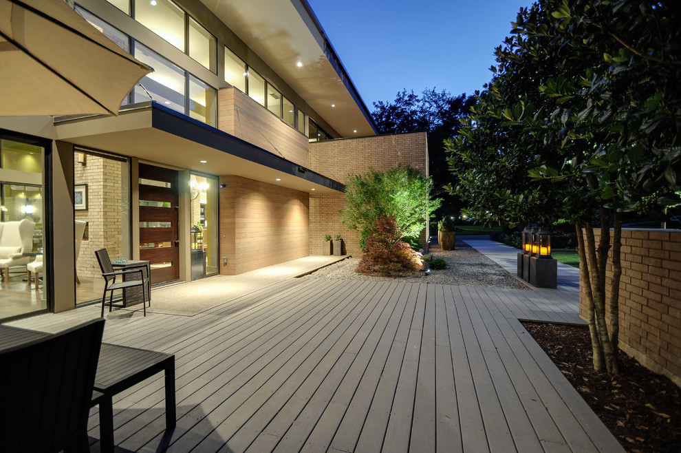 Design ideas for a large modern front patio in Dallas with decking and an awning.