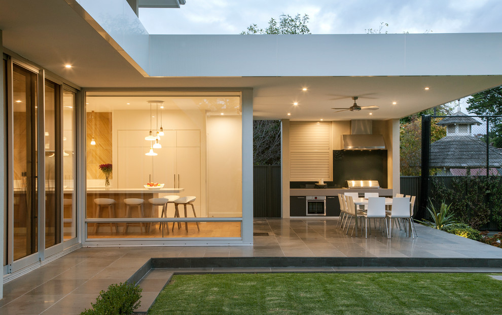 Aménagement d'une terrasse arrière contemporaine de taille moyenne avec une cuisine d'été, du carrelage et une extension de toiture.