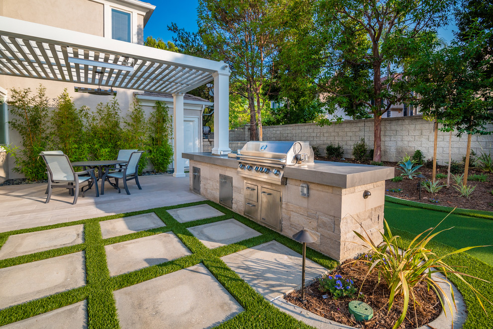 Große Moderne Pergola hinter dem Haus mit Outdoor-Küche und Natursteinplatten in Orange County