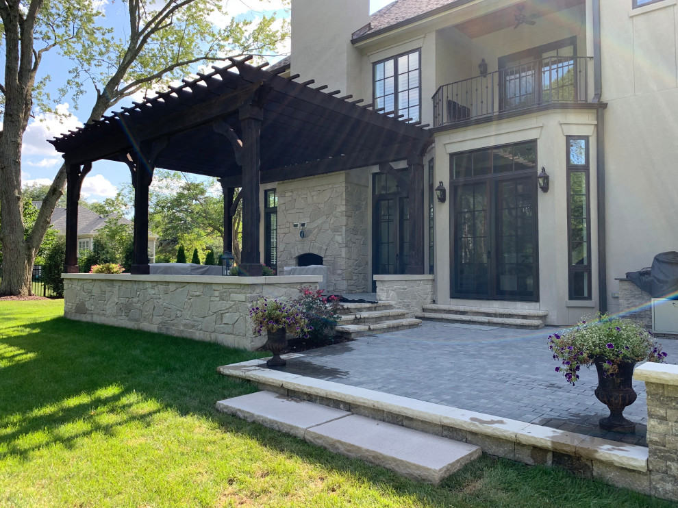 Immagine di un grande patio o portico design dietro casa con pavimentazioni in cemento e una pergola