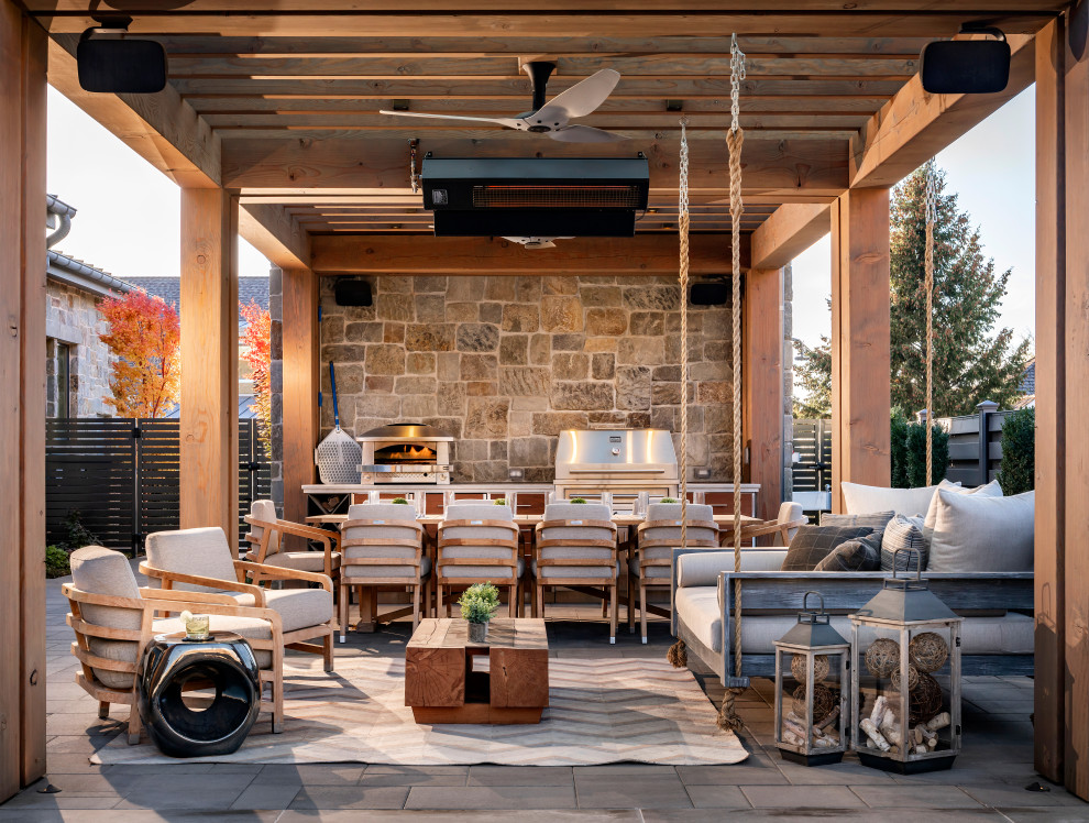 Modelo de patio campestre, extra grande, en patio trasero, con cocina exterior, adoquines de hormigón y pérgola