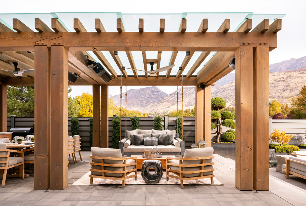 Idee per un ampio patio o portico country dietro casa con pavimentazioni in cemento e una pergola