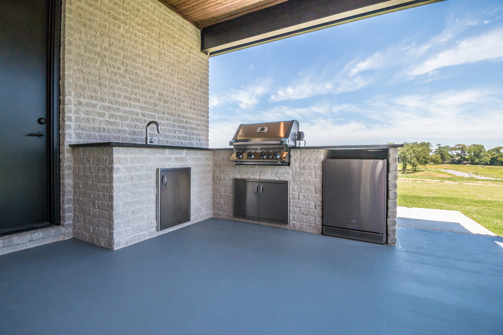 Inspiration for a large traditional back patio in Other with an outdoor kitchen, concrete slabs and a roof extension.