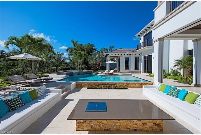 Large classic back patio in Miami with a water feature and no cover.