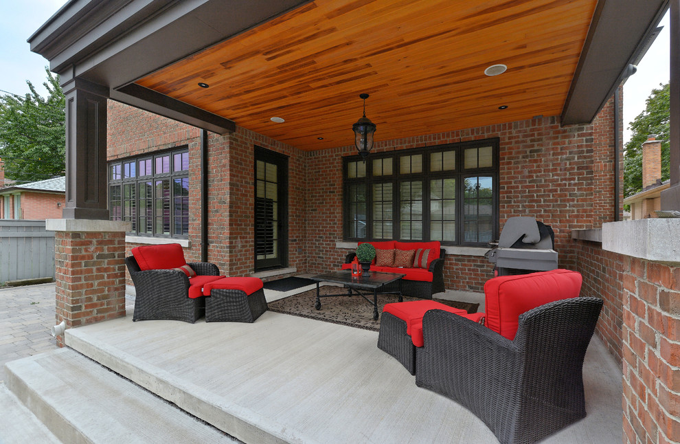 Esempio di un grande patio o portico tradizionale dietro casa con pavimentazioni in cemento e un tetto a sbalzo