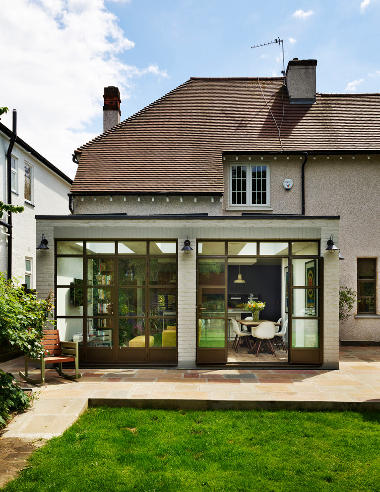 Photo of a large contemporary back patio in London with natural stone paving and no cover.