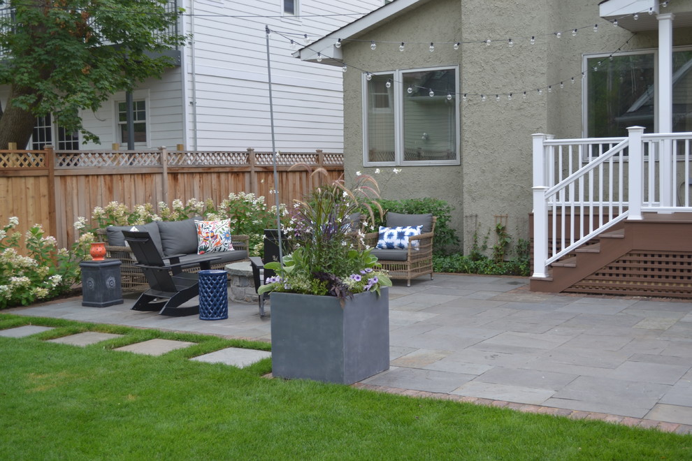 Inspiration for a large contemporary back patio in Chicago with a fire feature, natural stone paving and no cover.