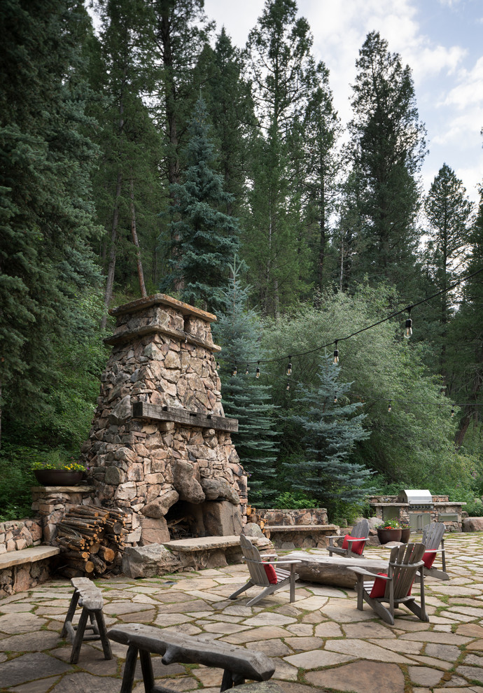 This is an example of a rustic back patio in Denver with no cover and a bbq area.