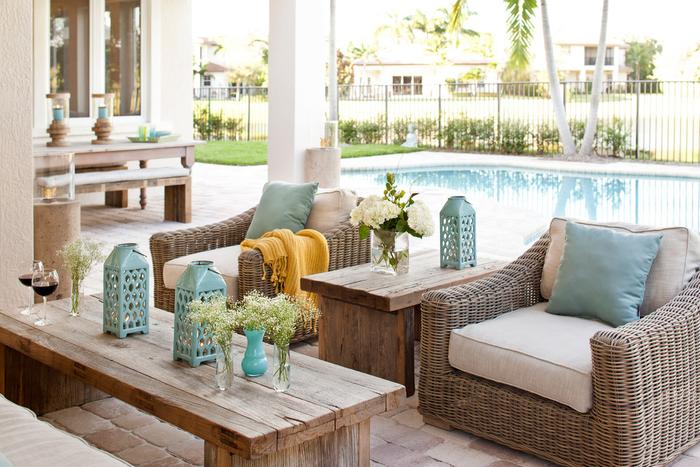Patio - large transitional backyard brick patio idea in Miami with a roof extension