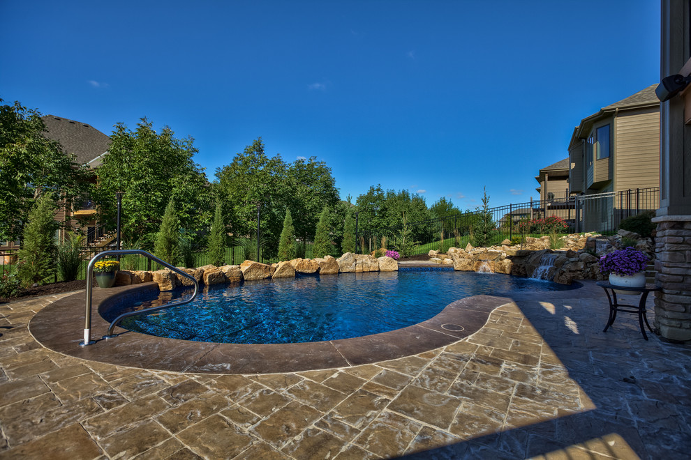 Inspiration for a mid-sized timeless backyard concrete paver pool fountain remodel in Omaha