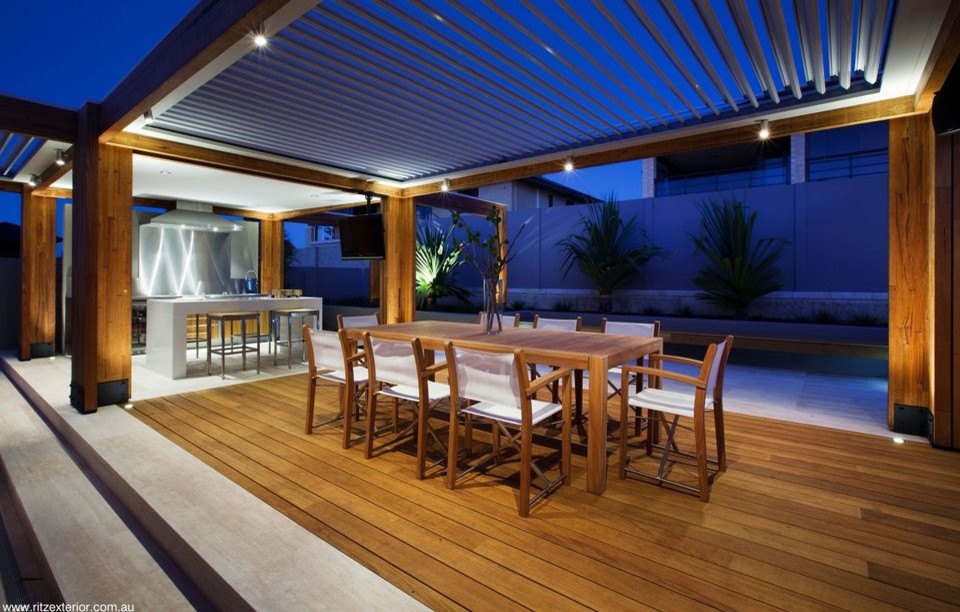 Exemple d'une très grande terrasse arrière bord de mer avec une cuisine d'été, du béton estampé et un auvent.
