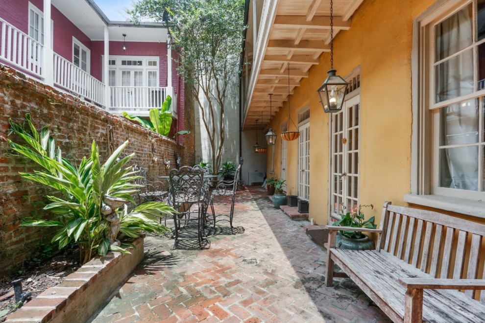 Inspiration for a small timeless courtyard brick patio remodel in New Orleans with an awning