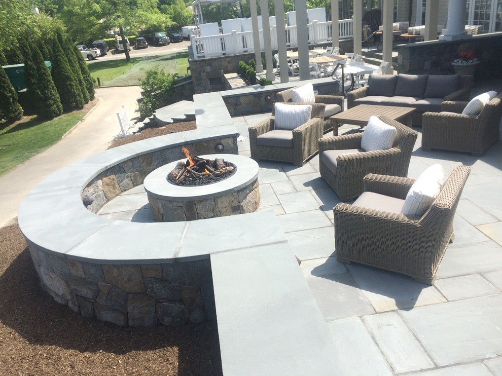 Inspiration for a large traditional back patio in New York with a fire feature, natural stone paving and no cover.