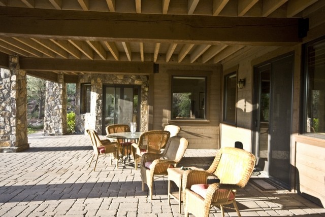 Immagine di un ampio patio o portico chic nel cortile laterale con fontane, pavimentazioni in pietra naturale e un tetto a sbalzo