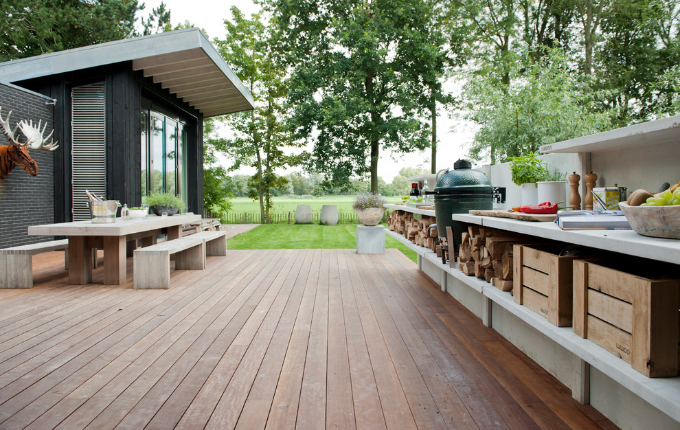 Diseño de patio contemporáneo de tamaño medio sin cubierta en patio trasero con cocina exterior y entablado