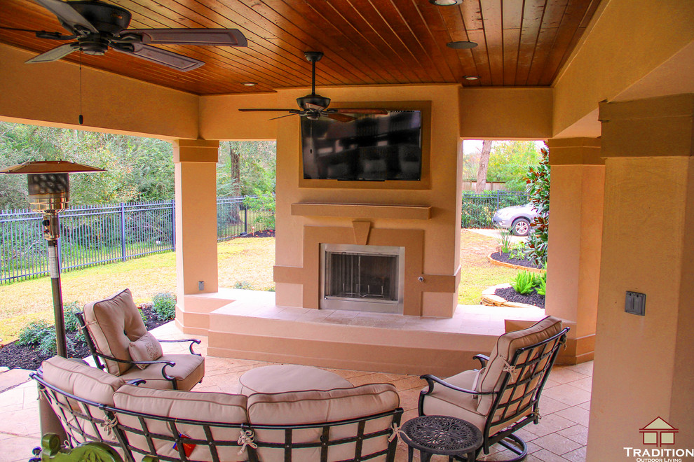 Example of a large classic backyard stamped concrete patio design in Houston with a fire pit and a roof extension