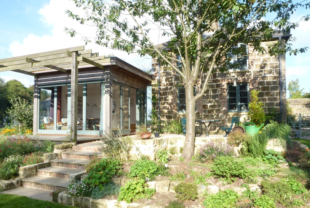 Diseño de patio de estilo de casa de campo pequeño con adoquines de piedra natural y pérgola