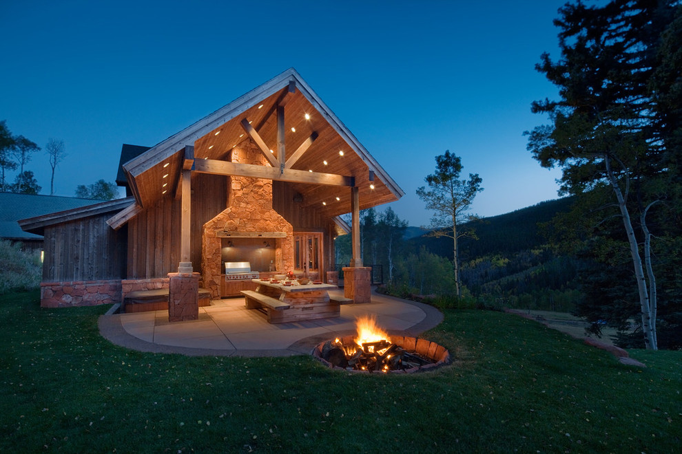 Example of a classic concrete patio design in Denver with a roof extension