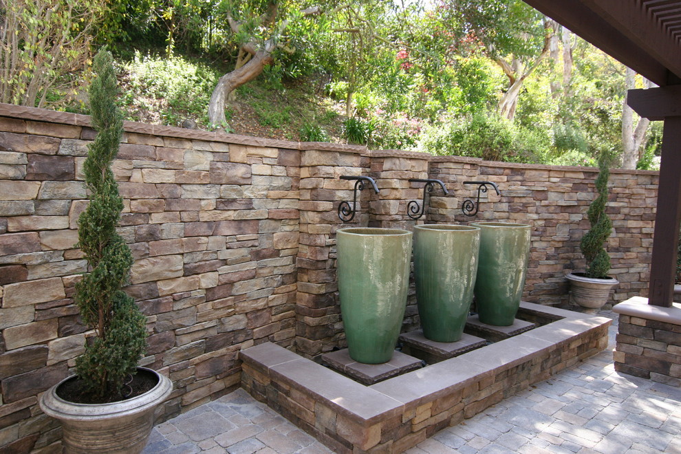 Mid-sized elegant backyard concrete paver patio fountain photo in Orange County with a pergola